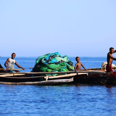 Ifaty, Madagascar - August 5, 2015: Fishermen paddle their dugout canoe to open waters off the coast of Ifaty in the Mozambique Channel.