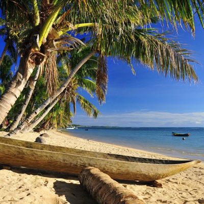 Vohilava, Nosy Boraha, Analanjirofo region, Toamasina province, Madagascar: dugout canoe under the coconut trees, tropical beach on the Indian Ocean - St Mary Island - Île Sainte Marie - photo by M.Torres